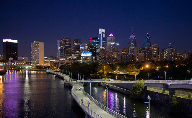 The Comcast Center stands tallest in the city skyline, with the new over-the-water Schuylkill Banks Boardwalk in the foreground.
